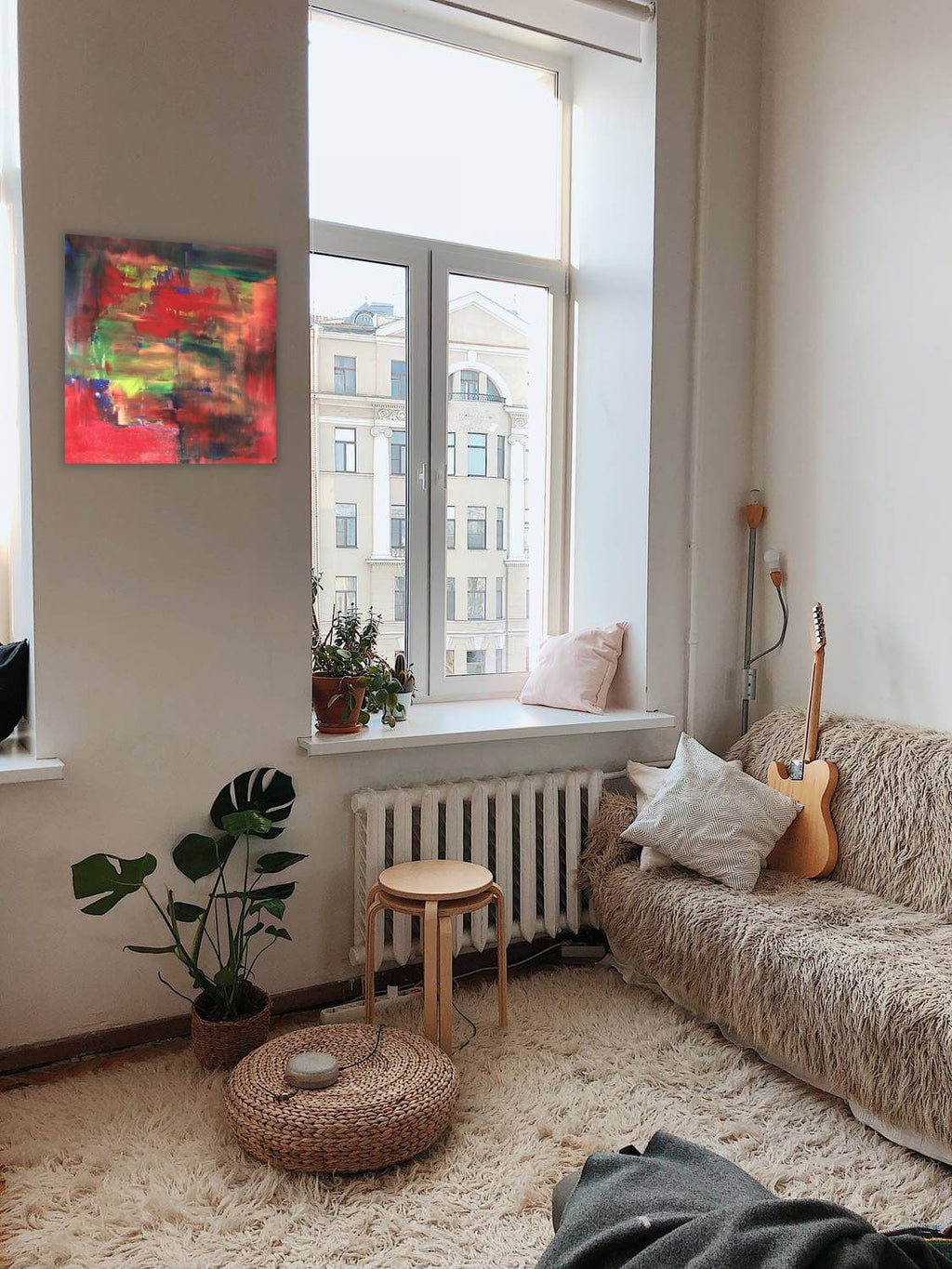 Abstractive by Alli Cullimore displayed on a white wall in a cosy living room — a small square abstract painting bursting with reds, greens, yellows and blues, Gallery 68"