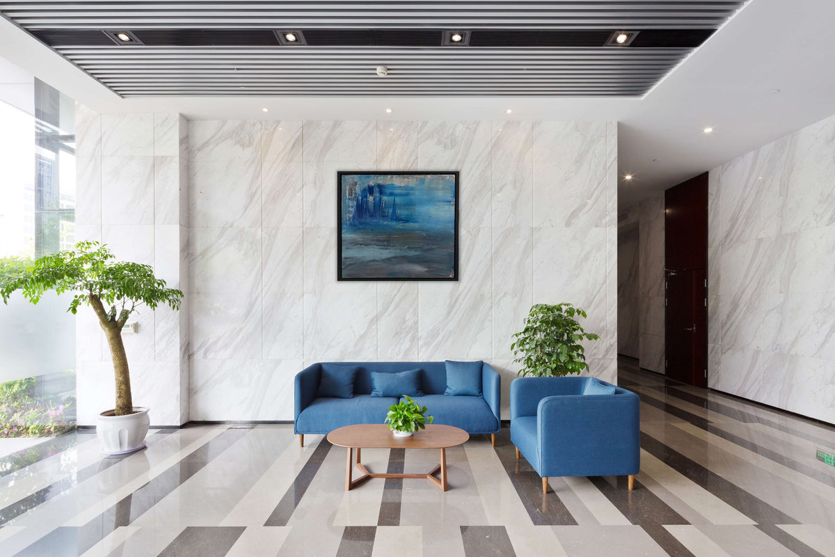 Stormy Seas original abstract painting by Alli Cullimore displayed in a modern reception area— 60×60cm acrylic on canvas in stormy blues and grey, in a black floating frame