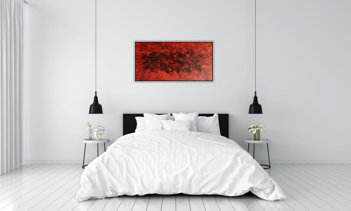 Fire by Alli Cullimore displayed above a bed in a minimalist white room — a wide landscape abstract painting in deep reds and black in a black floating frame, Gallery 68