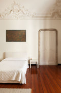Brushed Copper original textured artwork by Alli Cullimore, displayed on a white wall above a bed in an elegant room with ornate ceiling moulding and hardwood floors