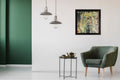 Amazonian by Alli Cullimore displayed on a white wall in a contemporary hallway with green velvet armchair and industrial pendant lights — a square heavily textured abstract painting in greens and yellow in a black frame, Gallery 68